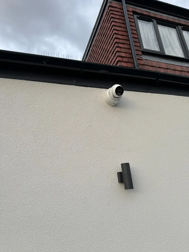 Dome camera mounted on a rendered wall under the eaves
